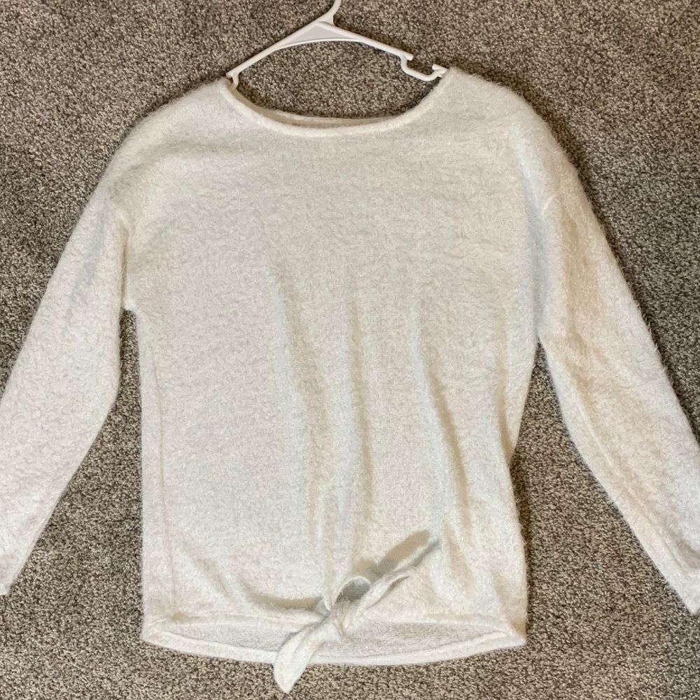 White sweater with tie detail on front.